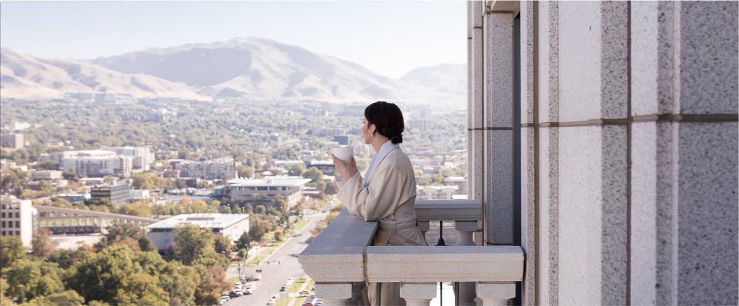 A hotel guest is enjoying the breathtaking view of the Wasatch Mountains from their hotel room.