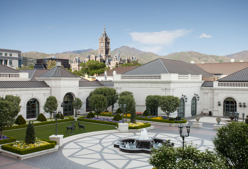 The Grand America center courtyard with a fountain in the middle and flower beds surrounding the outer edges of the courtyard