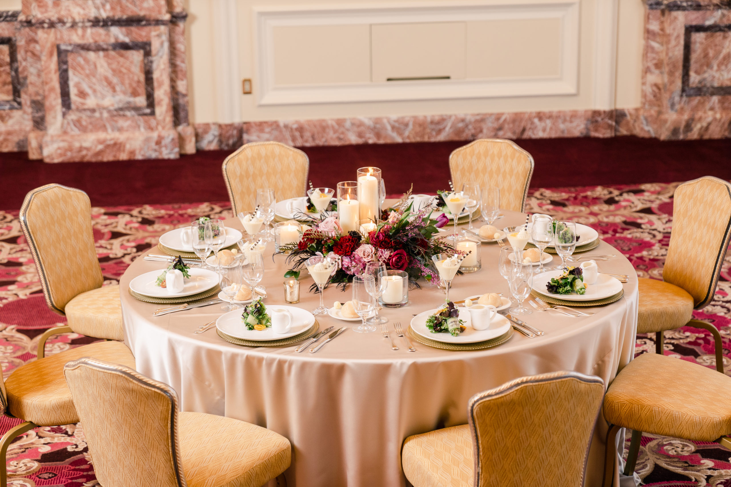 Wedding table set up with plated dinner salads in The Grand Salon.