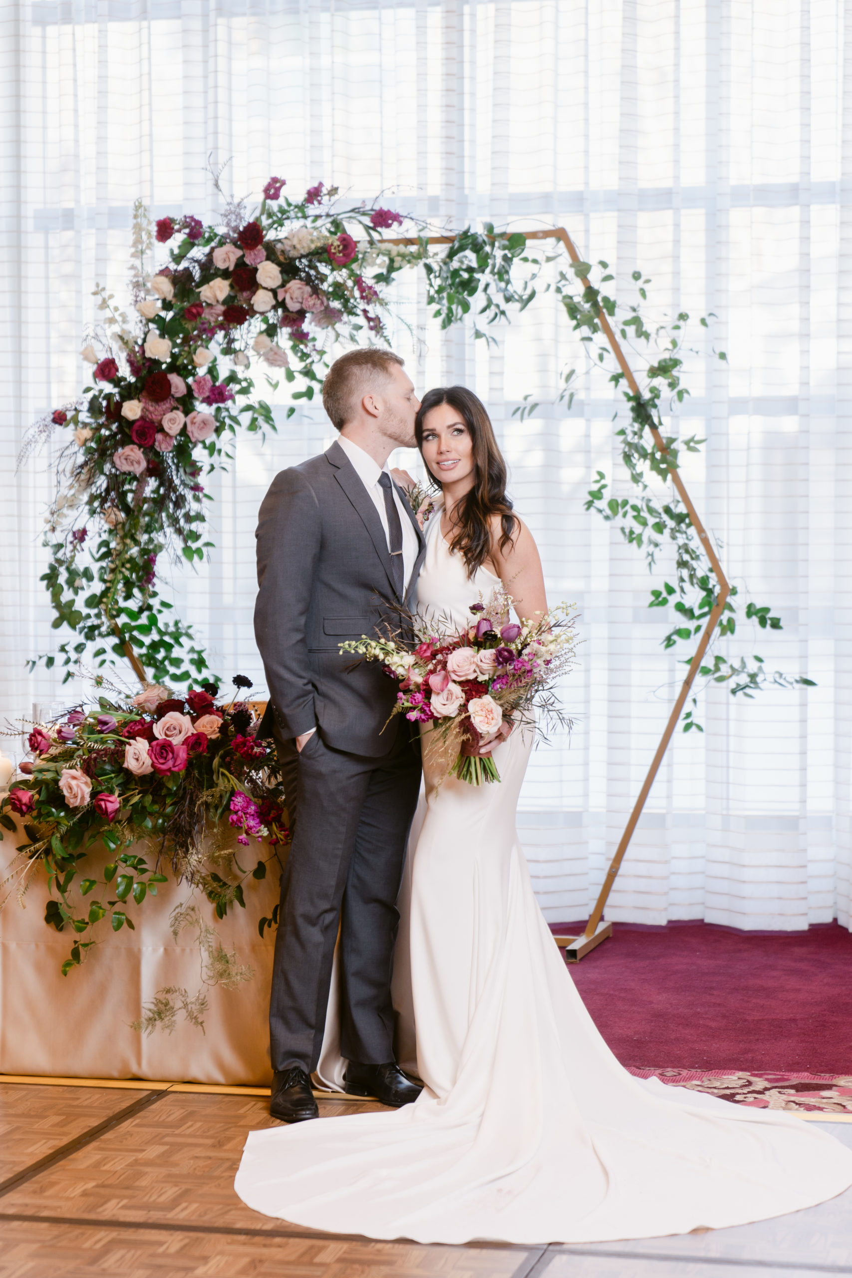 A bride and groom stand near their sweetheart's table.